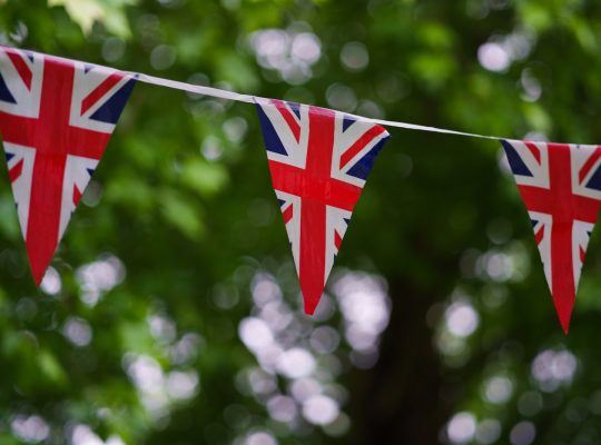 a british flag bunting on a tree line